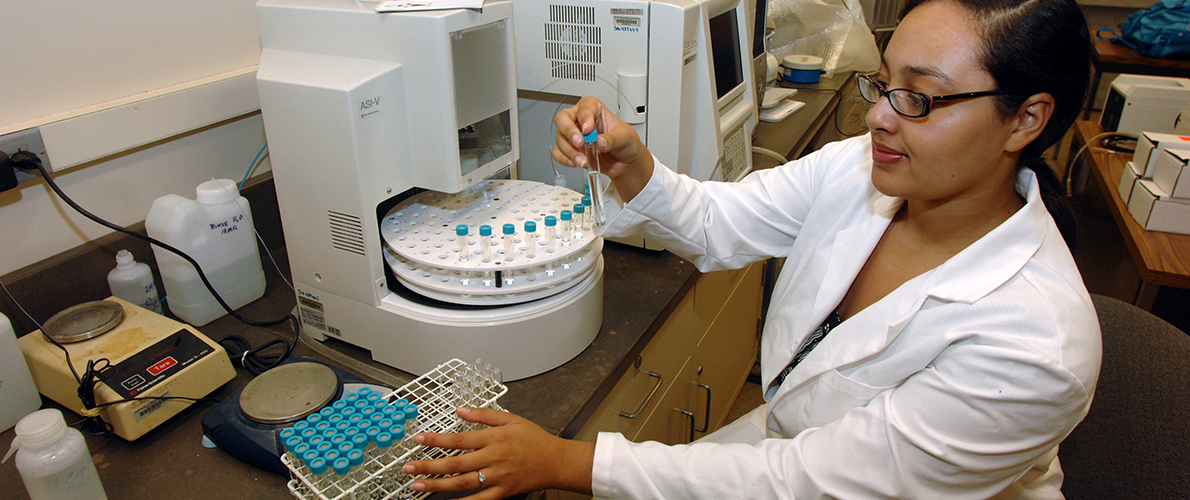 A woman wearing a white lab coat conducts research